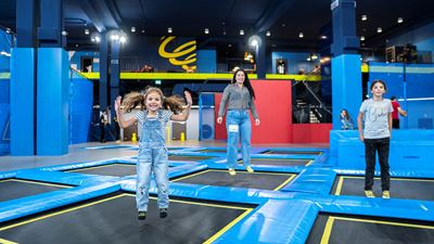 Eine Frau und zwei Mädchen auf grossen Trampolinen im Trampolinpark Flip Lab in Rümlang.