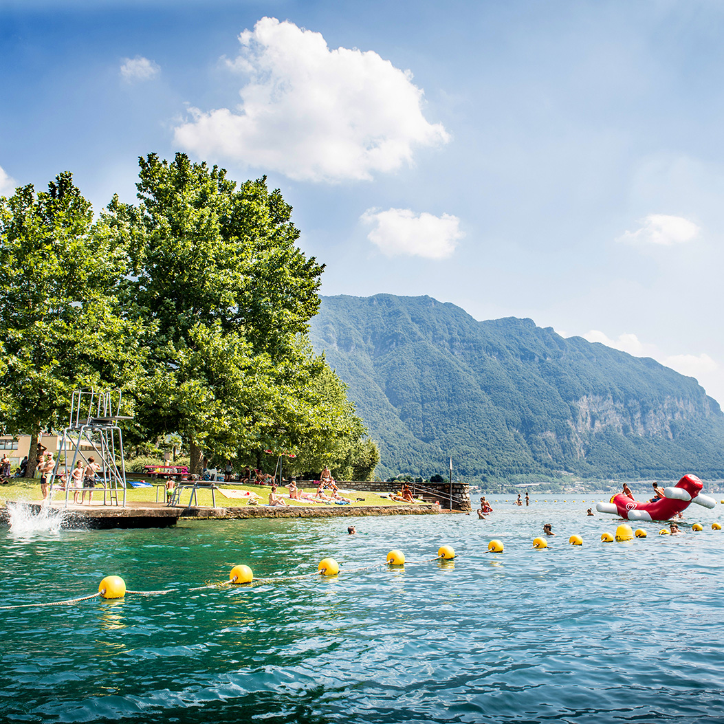Lido di Maroggia. Vista dal lago verso l’area balneare con i bagnanti.