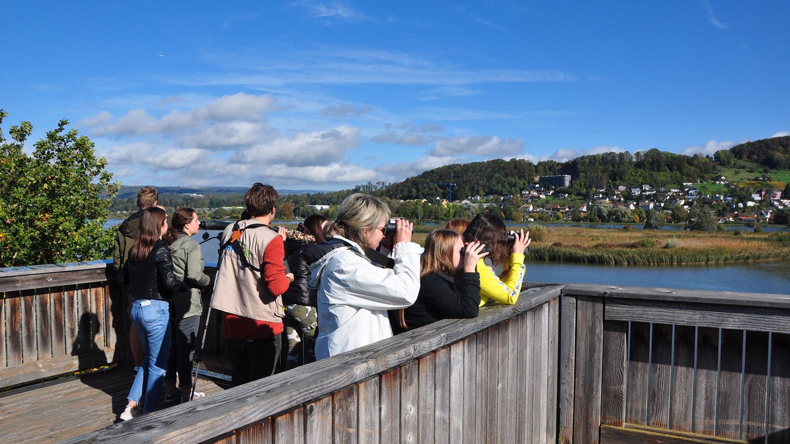 © Petra Zajec Un groupe de personnes sur une tour d’observation observe les alentours avec des jumelles.
