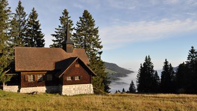 Die Kapelle Holzegg im Alpthal mit der schönen Aussicht auf das mit Nebelbedeckte Tal.