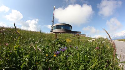 Le restaurant tournant du Hoher Kasten avec une prairie fleurie au premier plan.