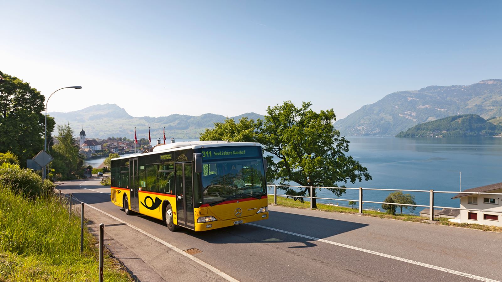 © Mike Niederhauser Merlin Photography Das Postauto fährt ab Beckenried Richtung Seelisberg. Im Hintergrund sieht man ein Teil des Vierwaldstättersees.      