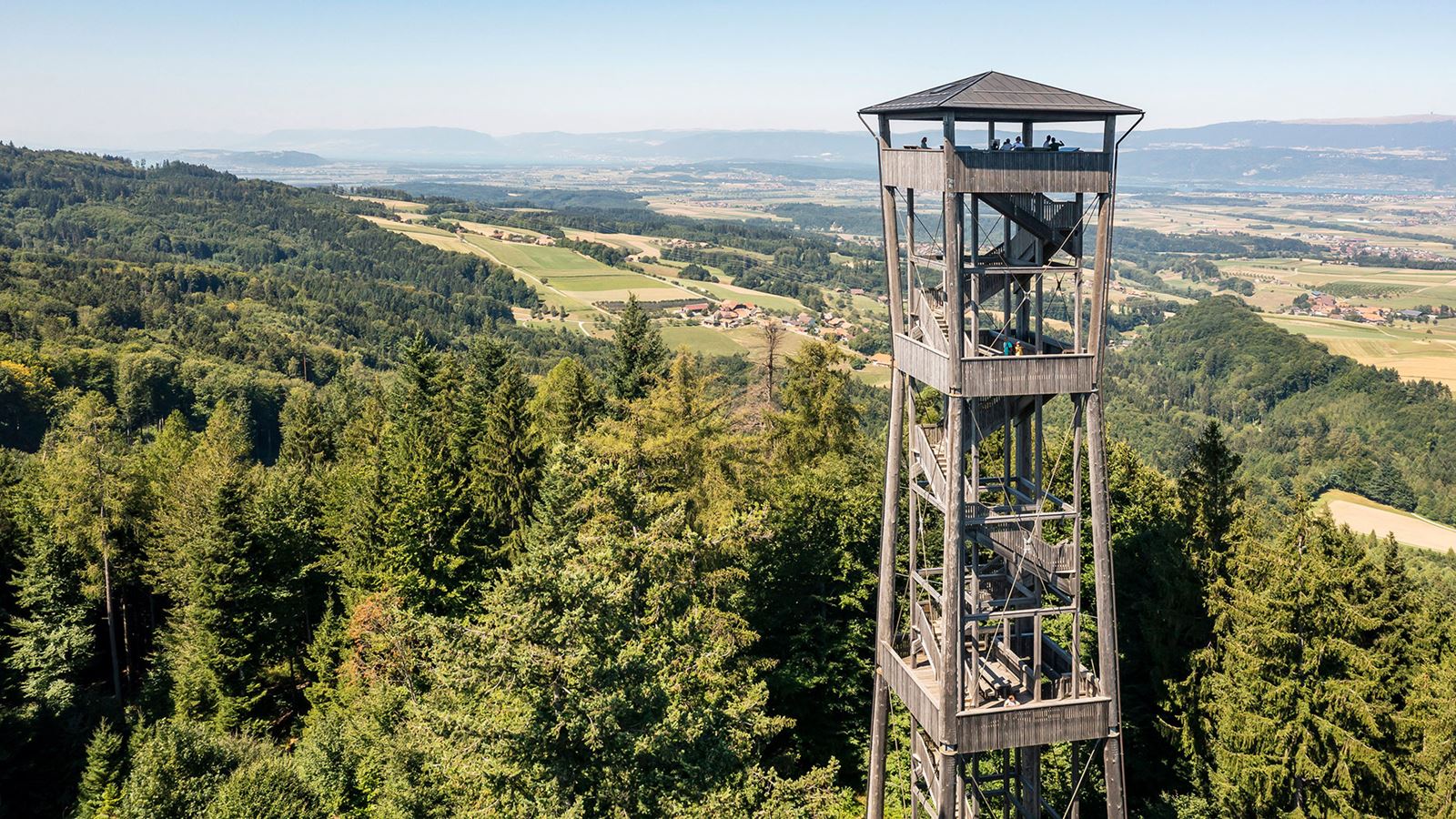 Drone photo of the top section of the Chutzenturm observation tower with a view over the Seeland region as far as the Chasseral. @Mike Niederhauser Merlin Photography