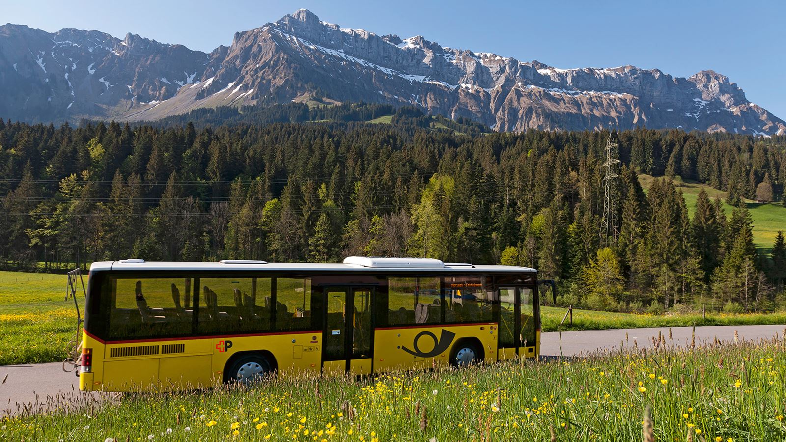 Postauto vor Bergkulisse