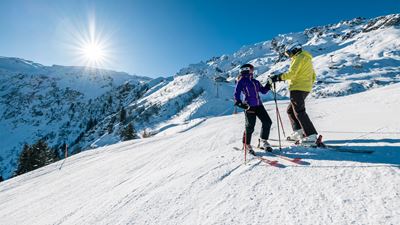 Zwei Skifahrer bei der Abfahrt auf der Skipiste