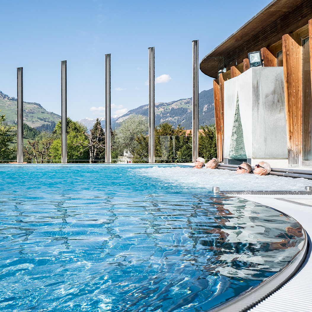 Des personnes dans les bains à remous de la piscine extérieure de la station thermale d’Andeer.
