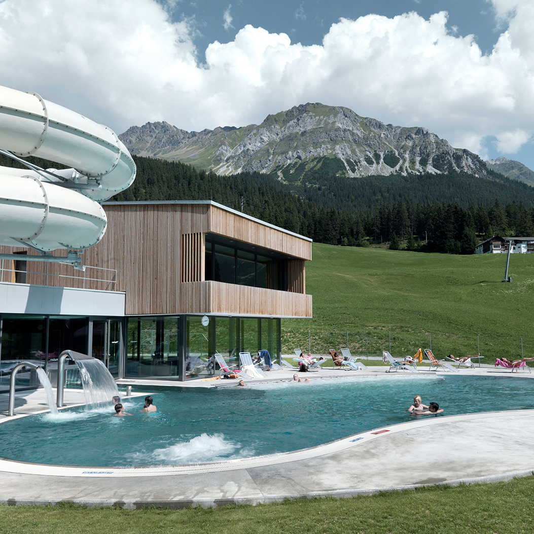 Aussenansicht des Wellnessbad H2Lai mit dem Aussenbecken sowie der Rutschbahn.