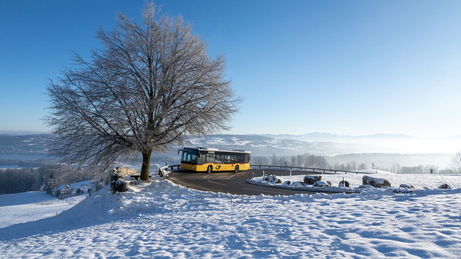 A Postbus travels over the Albis Pass in winter.