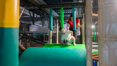 Un jeune garçon et une femme se trouvent sur un module d’escalade au Kiddy Park de Bülach.
