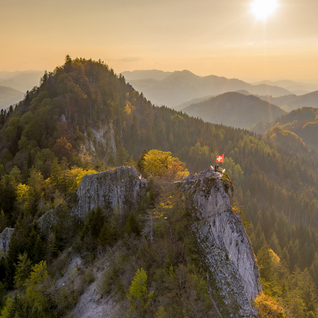 Blick auf den Berggipfel Belchenflue mit Schweizer Nationalfahne im Baselbieter Jura.