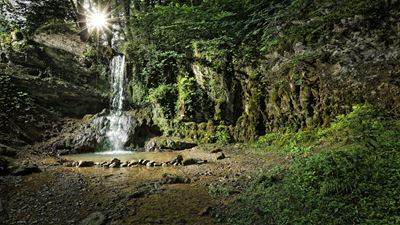The Linn waterfall splashes from a rock face into a shallow basin.