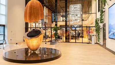 Modernes Eingangsfoyer mit großer skulpturaler Holzinstallation von Läderach