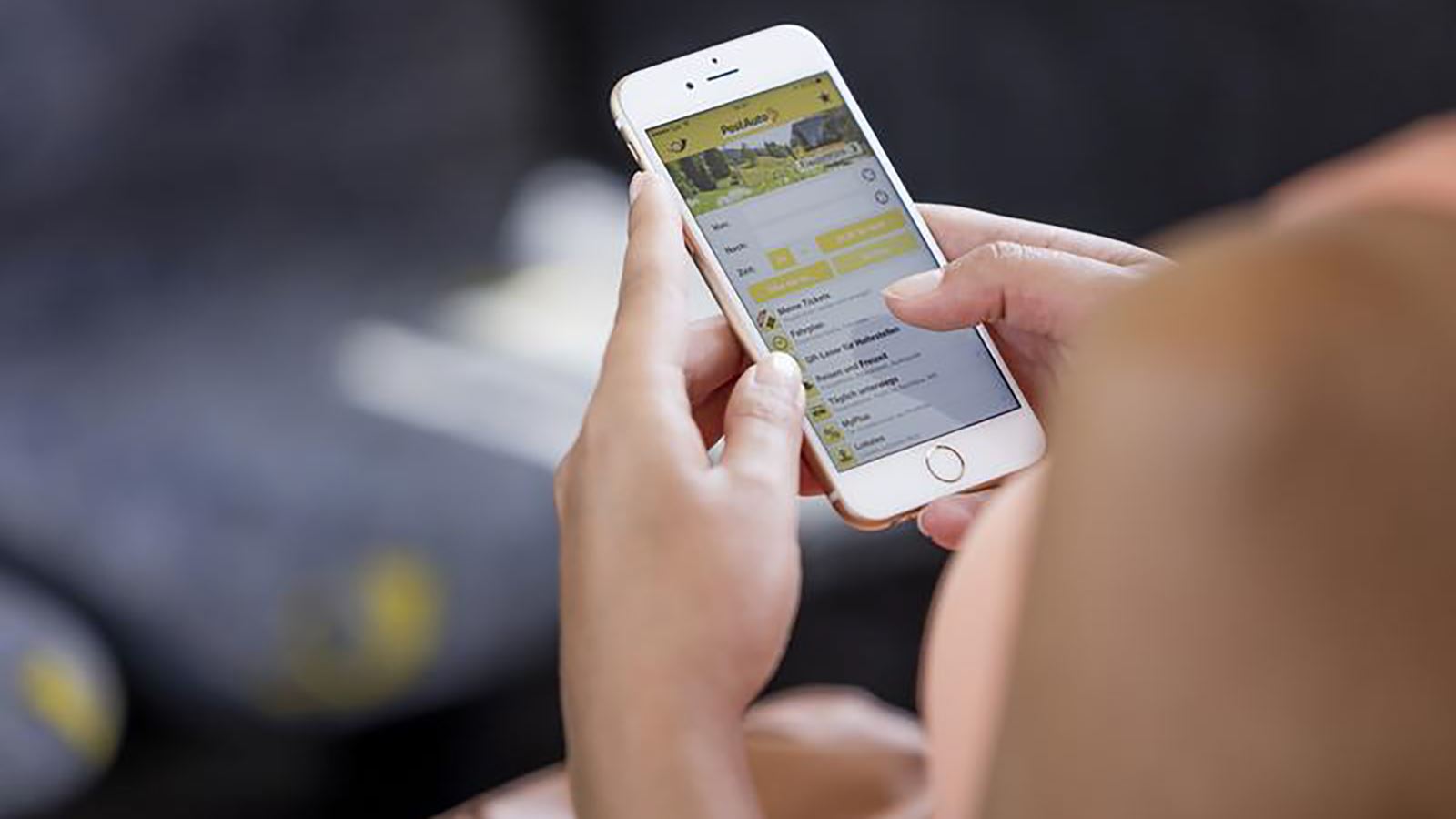 Una signora guarda il display del suo smartphone su cui è aperta la vecchia app di AutoPostale.