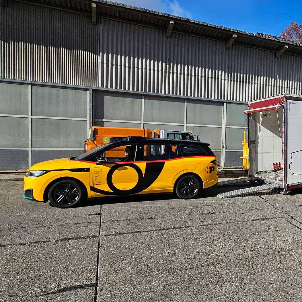 AmiGo vehicle drives out of a truck and arrives in front of the depot warehouse.