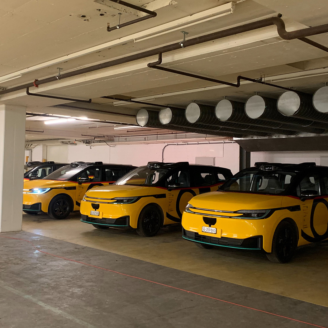 Eine Reihe AmiGo Fahrzeuge parkiert in der Tiefgarage des Depots.