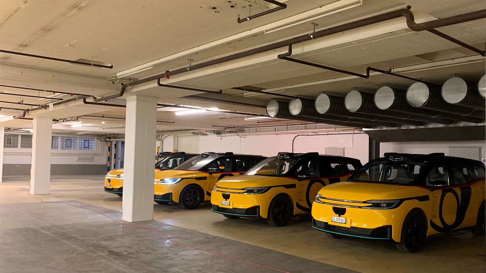 A number of AmiGo vehicles are parked in the underground car park of the depot.