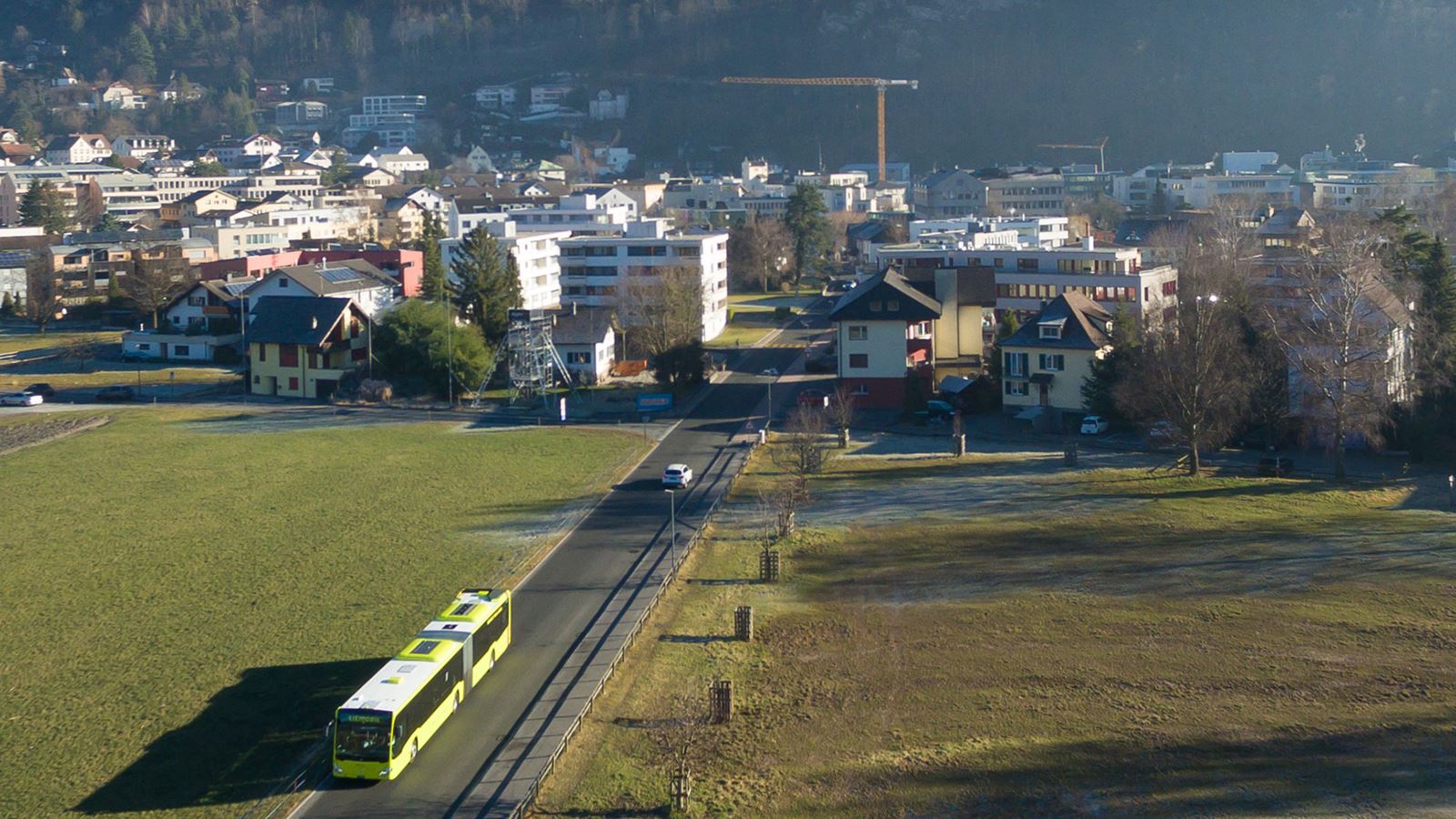 Eine Luftaufnahme eines Liemobil Buses welches auf einer Strasse in Liechtenstein fährt.  