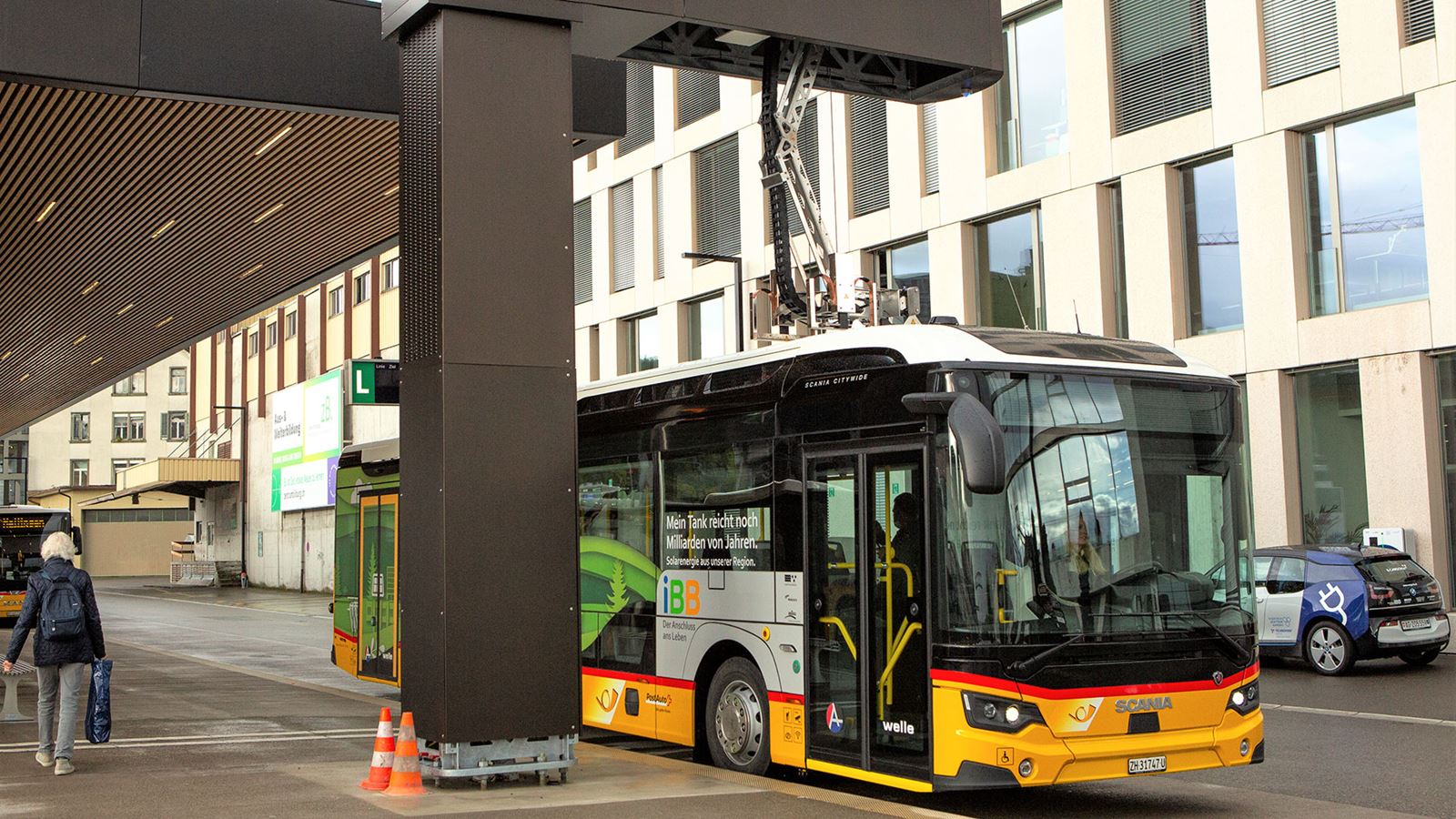 A Postbus with a pantograph that is docking at the charging station in Brugg. 
