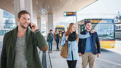 Voyageurs au terminal de bus «Bahnhof Campus» à Brugg.  À l’arrière-plan, on aperçoit un car postal à quai. 