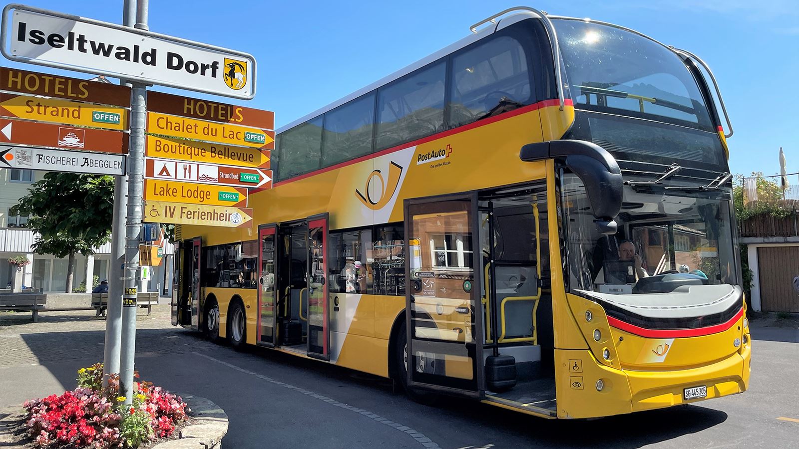 The double-decker Postbus is waiting for passengers in Iseltwald.