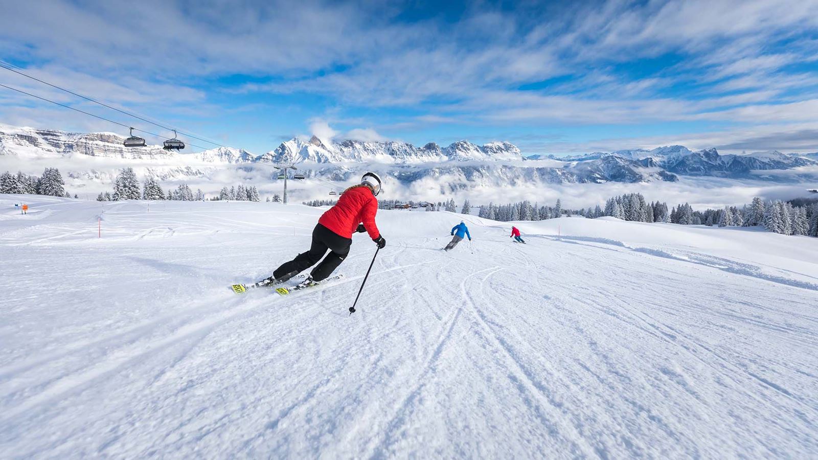 Eine Skifahrerin fährt bei schönem Wetter eine Piste in den Flumserbergen herunter.