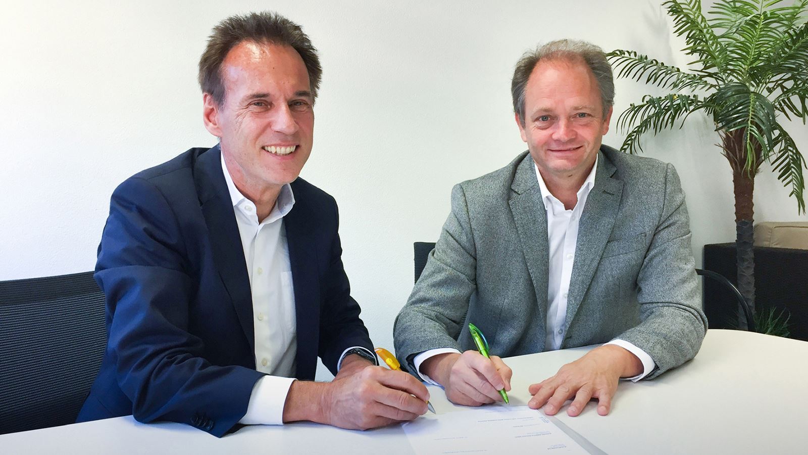 Christian Plüss, Leiter PostAuto (links), und Roberto Pronini, Direttore AET, haben eine Absichtserklärung für eine Kooperation im Bereich der Elektromobilität unterzeichnet. (PostAuto)