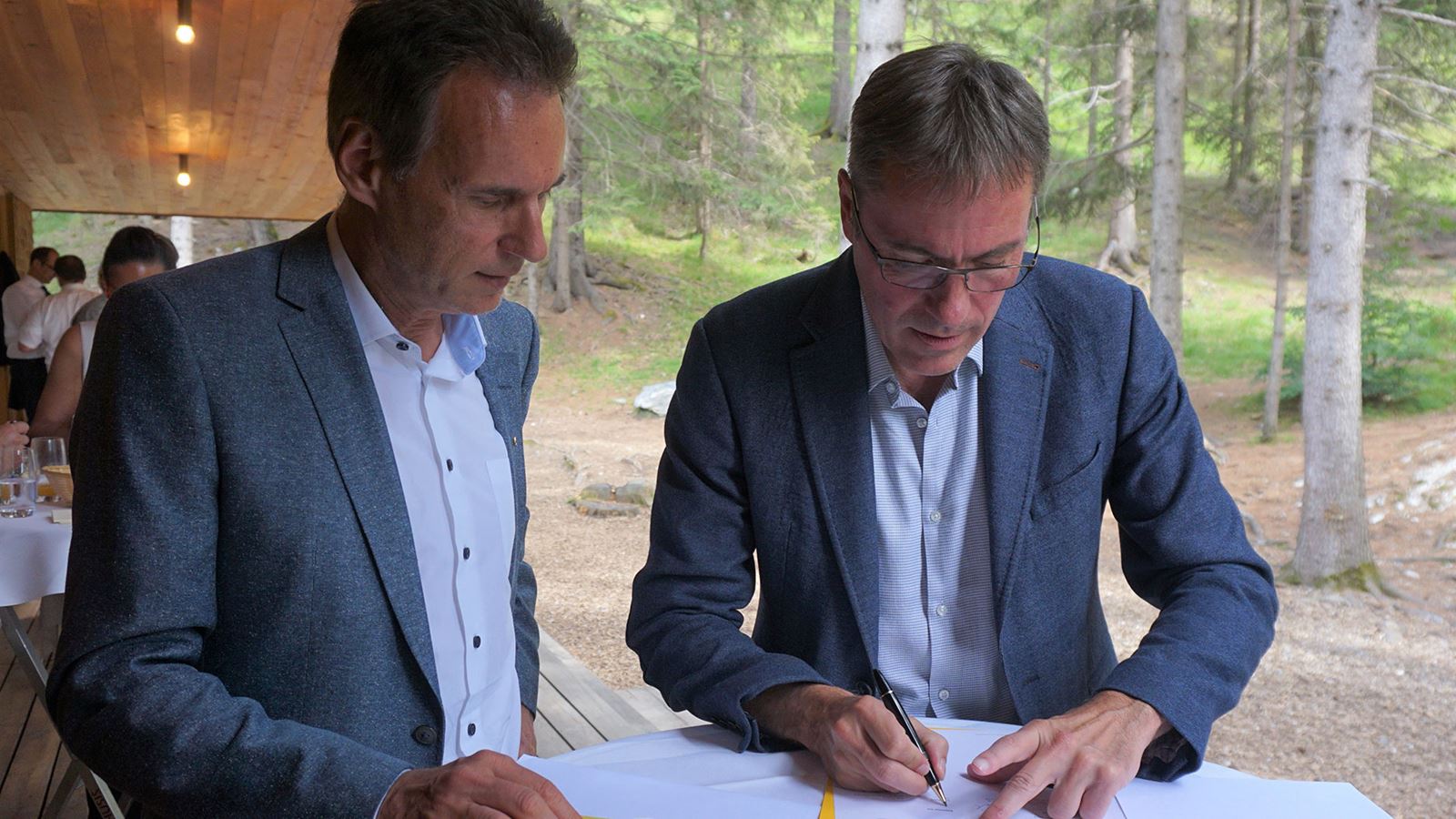 Christian Plüss, Leiter PostAuto (links), und Kurt Bobst, CEO Repower, haben eine Absichtserklärung für eine Kooperation im Bereich der Elektromobilität unterzeichnet. (PostAuto)